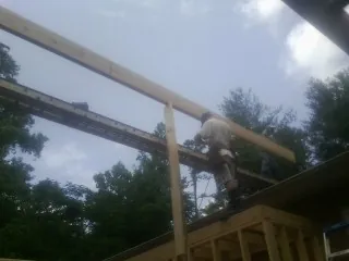Carpenter setting a ridge beam over a new addition frame — Ice Dam Removal by Roofing Brothers in Atwater
