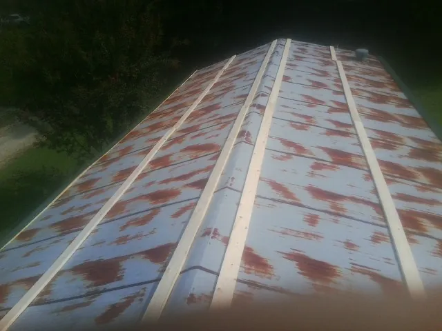 Rusted metal roof panels with new wood purlins before replacement — Storm Damage Roof Repair in Atwater by Roofing Brothers