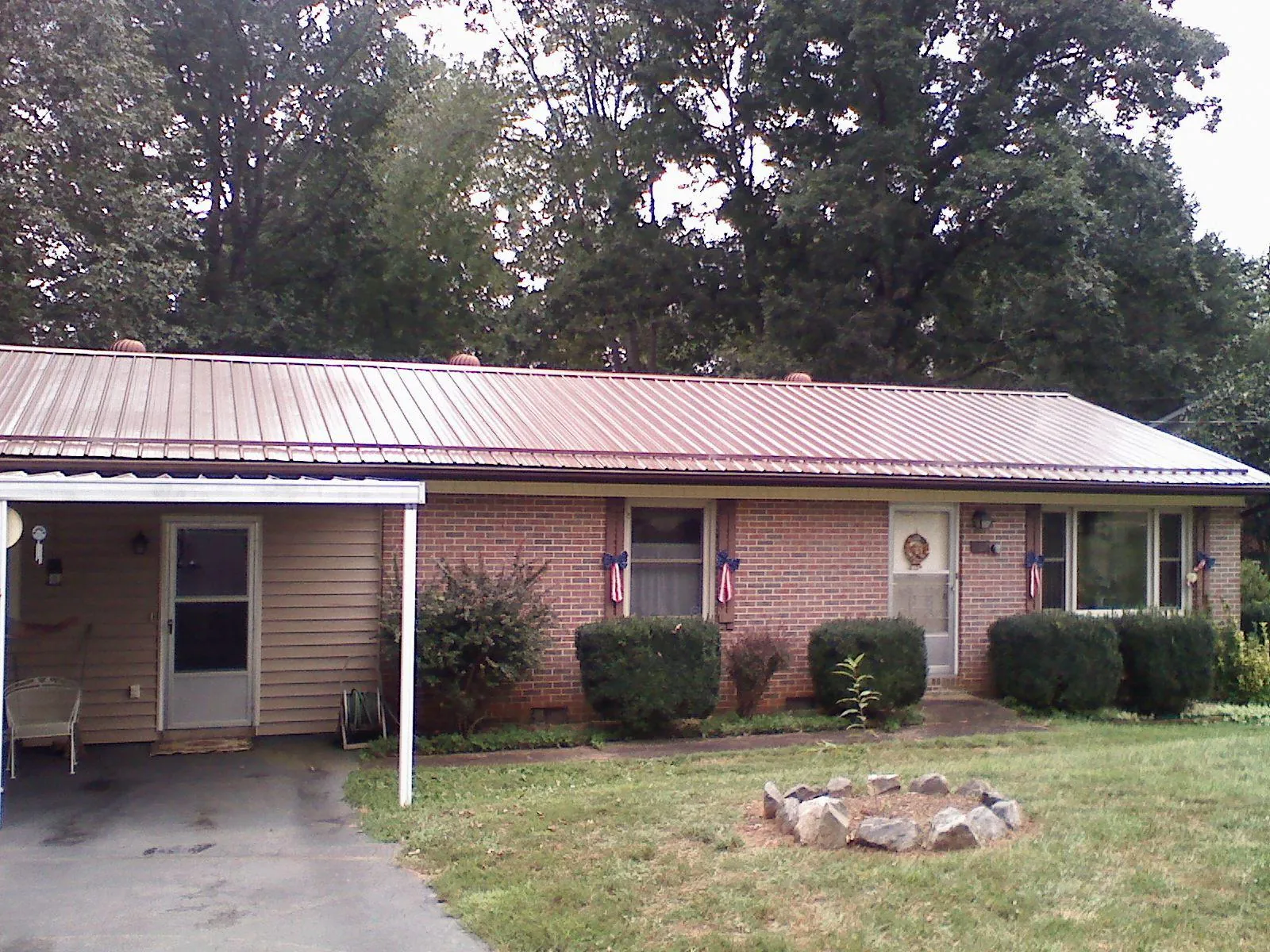 Bronze metal roof and carport on a brick ranch home — Roof Repair work by our crew in Atwater